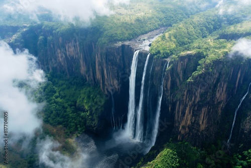 Breathtaking aerial view of a majestic cascading waterfall surrounded by lush greenery and mist. Creating a tranquil and serene natural wonder in a remote and scenic landscape
