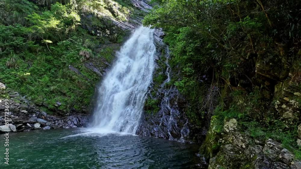 Waterfall in the mountain, spring water flowing down from high cliffs and rocks into nature's pool below, aerial view Waterfall in the mountain, spring water flowing down from high cliffs and rocks into nature's pool below, aerial view