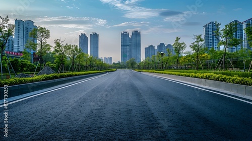 An empty road with a lot of trees and buildings in the background