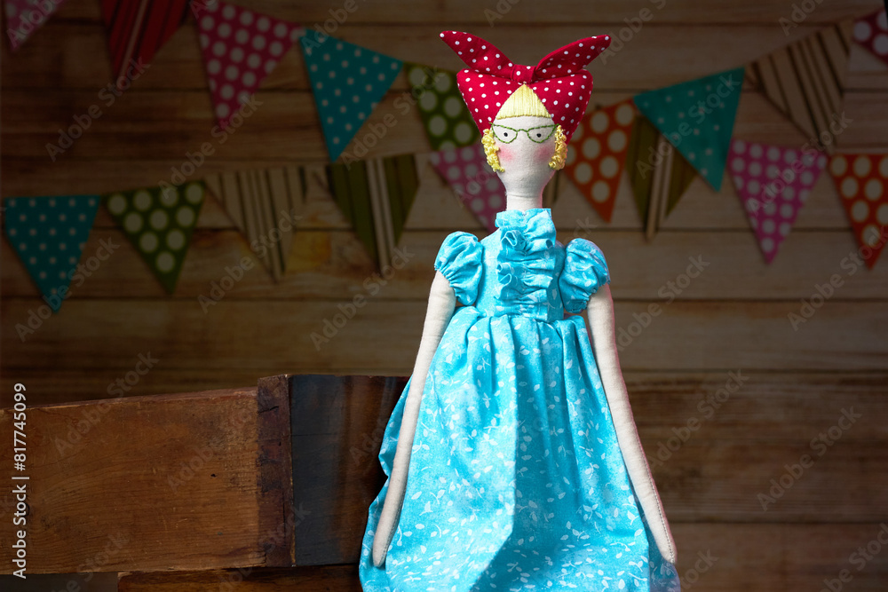 Handmade lady tilda doll in light blue dress with a red scarf on his head. Interior fairy doll