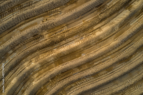 A top-down view of a freshly plowed field, with rows of soil creating a textured pattern.