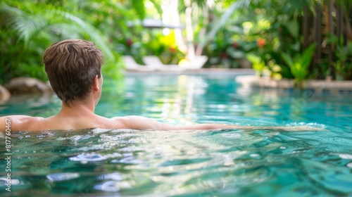 Young man enjoying a peaceful and relaxing time in the serene ambiance of a resort pool
