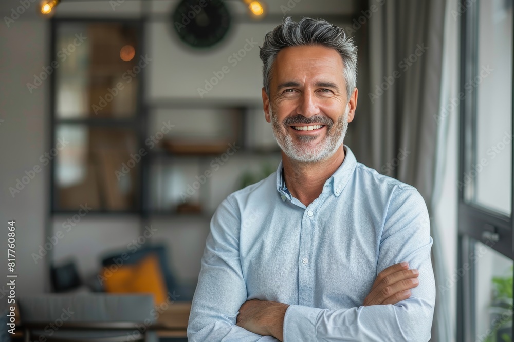 Naklejka premium Smiling middle aged businessman looking at camera, portrait. Confident happy mature older professional businessman executive manager, male investor in shirt standing arms crossed in office.