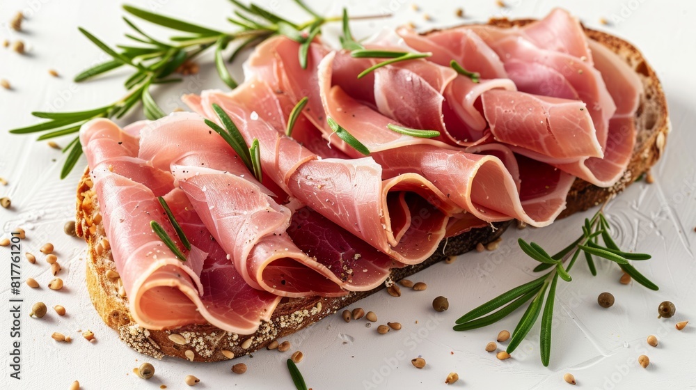 fresh ham in thing slices with fresh rosemary on a thin oval slice of bread with sesame seeds in the crust in white background fresh ham in thing slices with fresh rosemary on a thin oval slice of bread with sesame seeds in the crust in white background