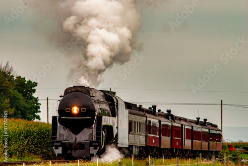 фотографія Vintage steam locomotive engine chugging along the railroad tracks
