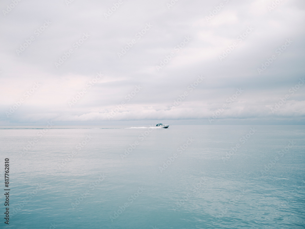 Small vessel sailing through choppy waters on a cloudy day, with no other vessels in sight. Small vessel sailing through choppy waters on a cloudy day, with no other vessels in sight.