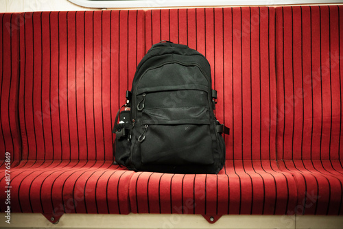 a black bag on the seat in bus. Abandoned, unattended cabin backpack on chair inside subway train.
