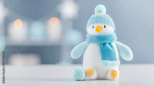 Plush penguin toy with colorful knitted blankets, soft focus background.