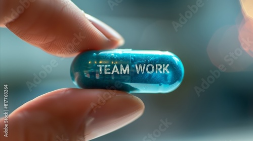 Fingers holding a blue mini pill with text TEAMWORK