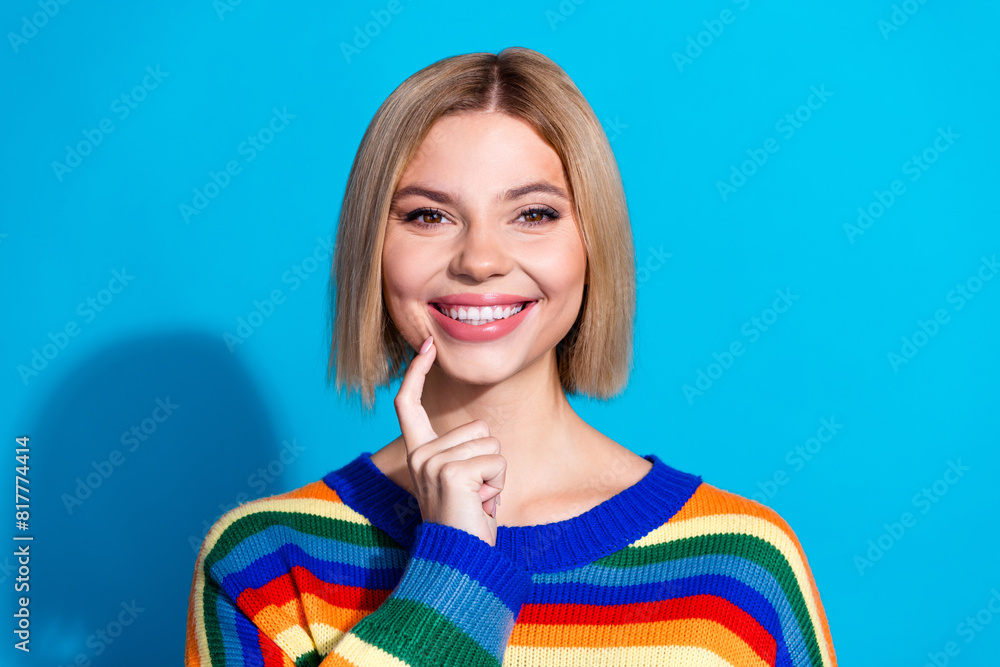 Fototapeta premium Portrait of pretty young girl finger touch chin wear striped pullover isolated on blue color background