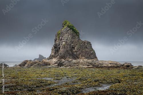 a rock on the edge of water near a body of water photo