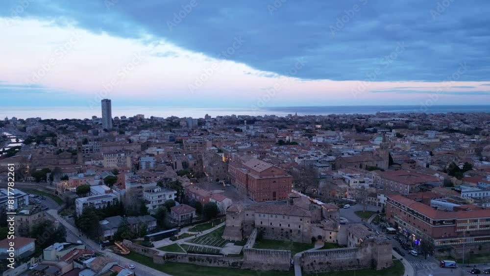 High drone shot of Castel Sismondo with the cityscape of Rimini in the background at sunset, Italy High drone shot of Castel Sismondo with the cityscape of Rimini in the background at sunset, Italy