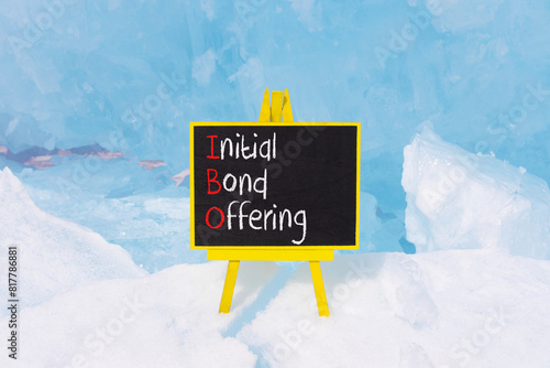 IBO initial bond offering symbol. Concept words IBO initial bond offering on beautiful yellow blackboard. Beautiful blue ice background. Business IBO initial bond offering concept. Copy space.
