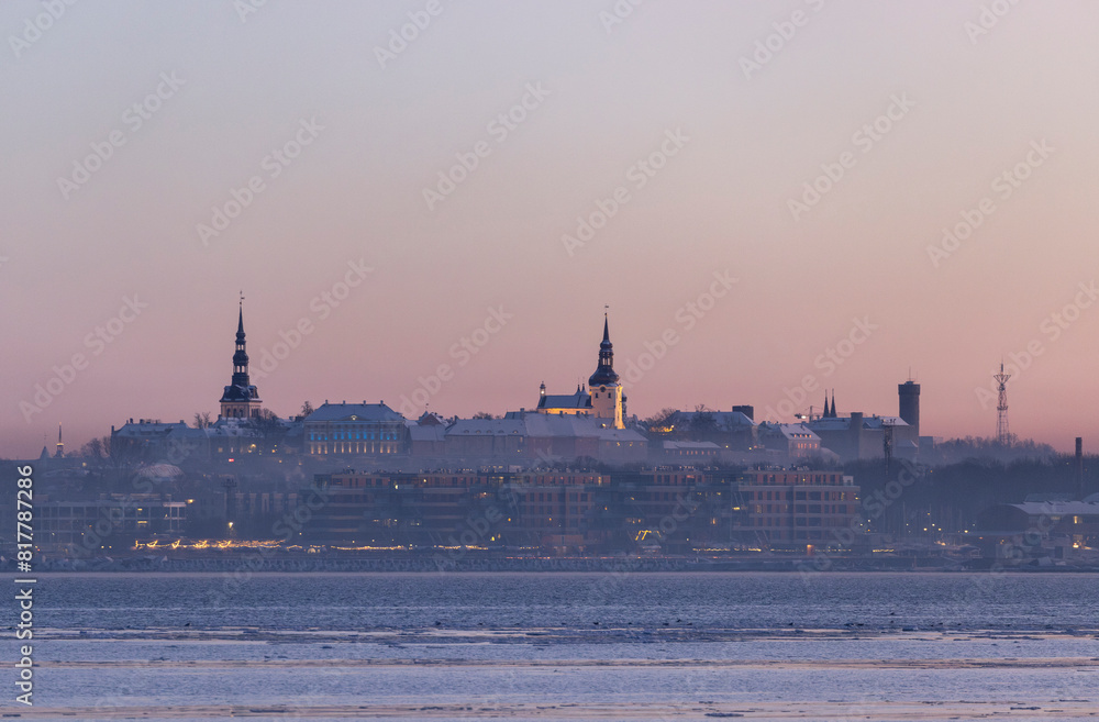 Obraz premium Scenic view of the skyline of Tallinn city skyline over the sea bay at sunset