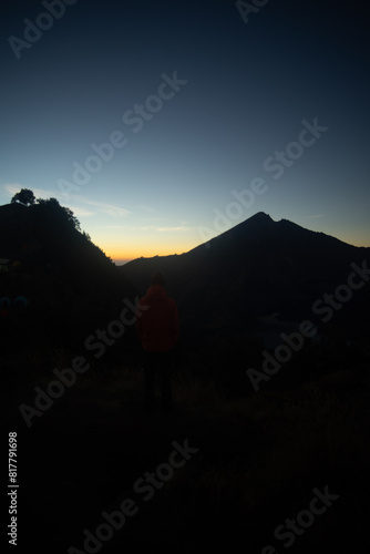 Wallpaper Mural A person standing in silhouette against a sunrise behind mountains. Torontodigital.ca