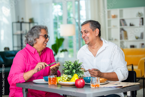 Obraz na płótnie senior Indian asian mid age couple having fun during a breakfast at home