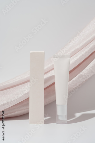 Blank cream tube and box on pink draping background