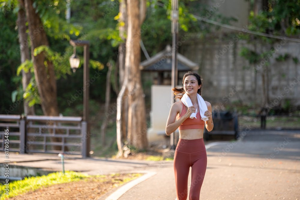 A woman is running in a park with a towel in her hand A woman is running in a park with a towel in her hand