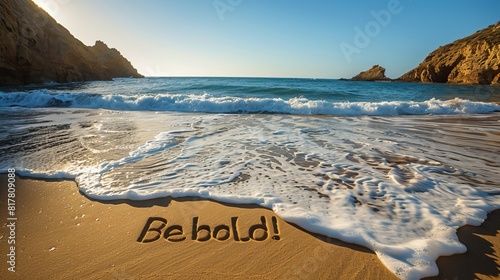 A picturesque beach scene with "Be bold!" carved in large letters into the golden sand, waves gently lapping nearby