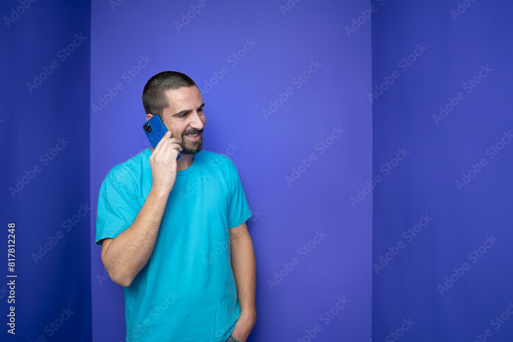 Happy young man talking with mobile phone on color background. High quality photo Happy young man talking with mobile phone on color background. High quality photo