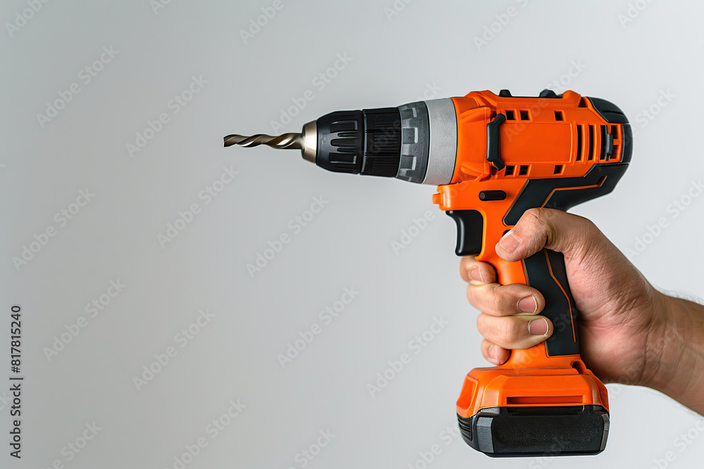 New cordless powered drill in male hand on white background New cordless powered drill in male hand on white background