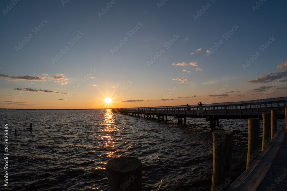 Obraz premium a pier over looking a wide open body of water at sunset