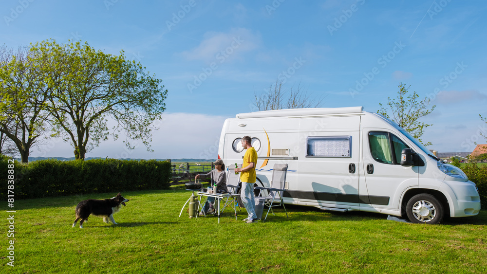 A man and his faithful dog stand next to an RV in a picturesque grassy field in Texel Netherlands, soaking in the serenity of their surroundings. a couple at a camping farm