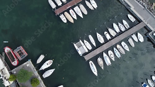 Ascending drone footage of boats moored at the Iseo heliport on Lake Iseo in Lombardy, Italy photo