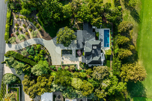 an aerial view of a large house and gardens with a lawn in front © Wirestock