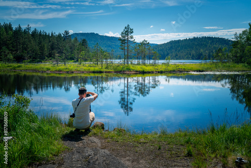 Summer Serenity:Traveler overlooking Reflective Mire in Norway's Stunning Landscape photo