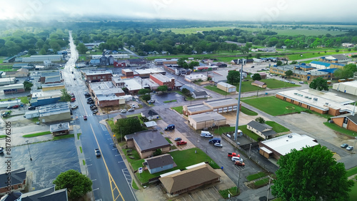 Gentry avenue along historic downtown of Checotah in McIntosh County, Oklahoma under foggy misty morning, aerial view small town with red brick buildings, antique malls, quiet street early summer photo