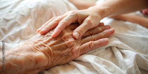 A young hand touches the palm of an old hand lying on the bed, hospital theme, help for the elderly and care for the elderly, end-of-life support, home for the elderly, solidarity and help