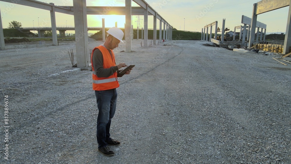 Caucasian mechanical engineer checking construction site building at sunset Caucasian mechanical engineer checking construction site building at sunset