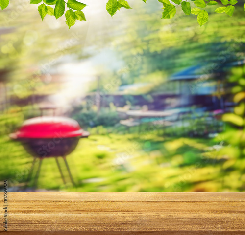 summer time party in backyard garden with grill BBQ, wooden table, blurred background © andreusK