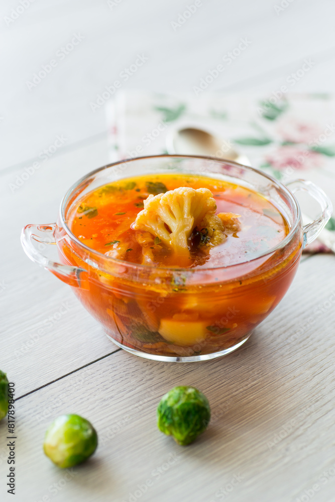 vegetable soup with Brussels sprouts and cauliflower, in a glass plate on a wooden table vegetable soup with Brussels sprouts and cauliflower, in a glass plate on a wooden table