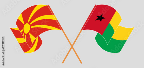 Crossed and waving flags of North Macedonia and Guinea-Bissau