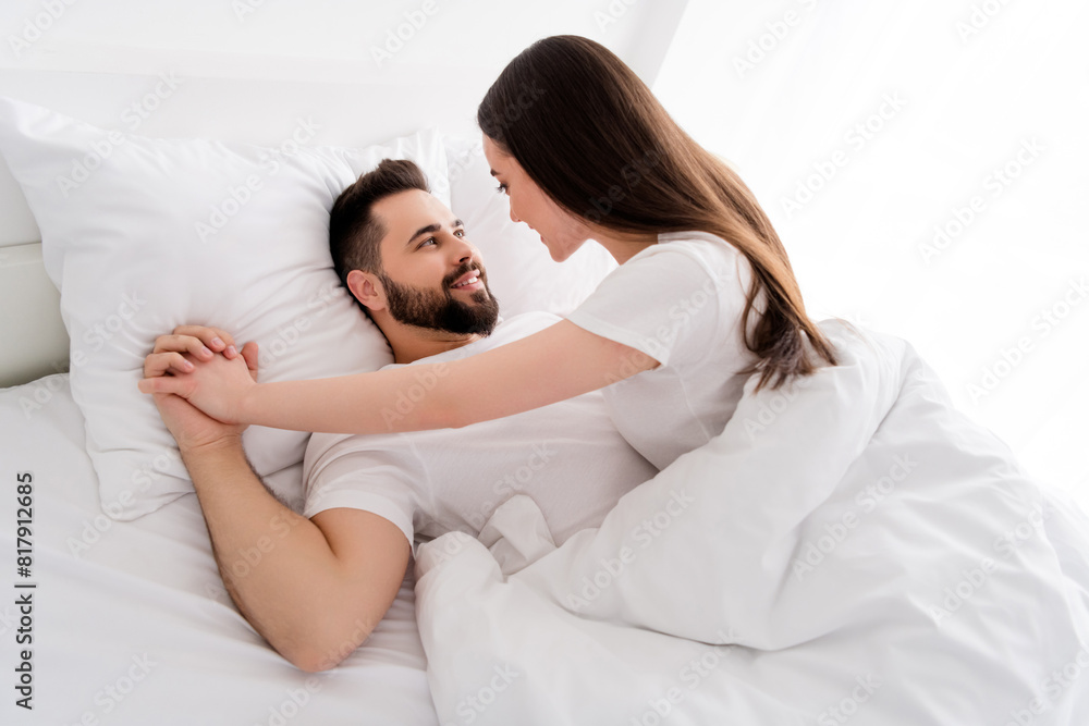 Photo of good mood charming couple wear white t-shirts embracing indoors apartment bedroom Photo of good mood charming couple wear white t-shirts embracing indoors apartment bedroom