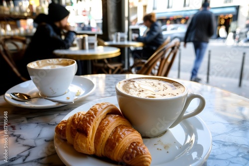 A cozy cafe scene featuring a cappuccino and croissant on a marble table  with blurred patrons in the background creating a relaxed atmosphere.