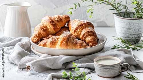delicious croissants accompanied by a glass of milk, showcased in a close-up shot bathed in the soft morning light, evoking a warm and cozy atmosphere perfect for breakfast.