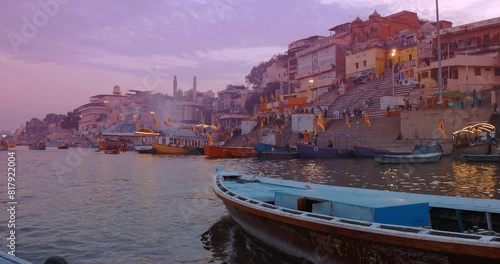 Varanasi, Uttar Pradesh, India. Many Boats moored on Ganga river near ghats. Hundreds of tourists and locals come in boats to watch Ganga Maha Aarti ceremony and the fire ceremony. Purple sunset sky