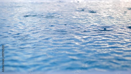 Rain drops falling onto the surface of a swimming pool