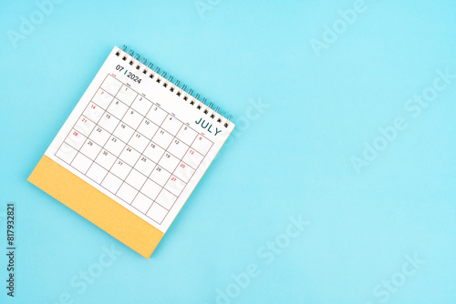 2024 July Desk Calendar On Blue Background. Composition with copy space.