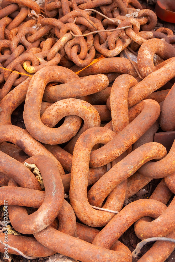 A heap of rusty chain, heavy links of steel from a ships anchor now waiting to be recycled into new steel. A heap of rusty chain, heavy links of steel from a ships anchor now waiting to be recycled into new steel.
