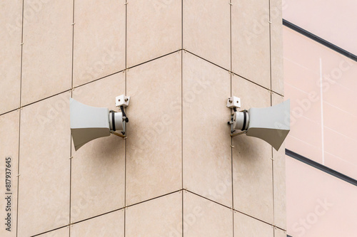 Fotografie Two large speakers are mounted on a building