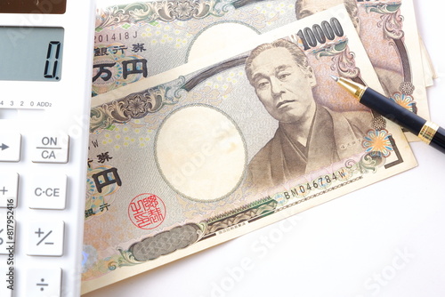 福沢諭吉の肖像の一万円紙幣と電卓、ペン
 photo