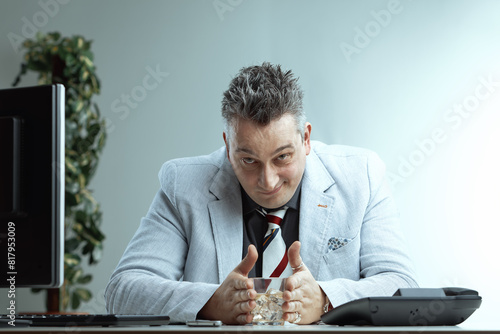 Smug man drinks alcohol at work, thinking it's normal photo