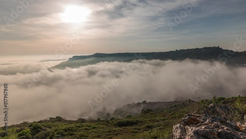 Panorama showing aerial View of Sesimbra Town and Port covered by fog timelapse, Portugal. Top landscape above the clouds and setting sun. Resort in Setubal district photo