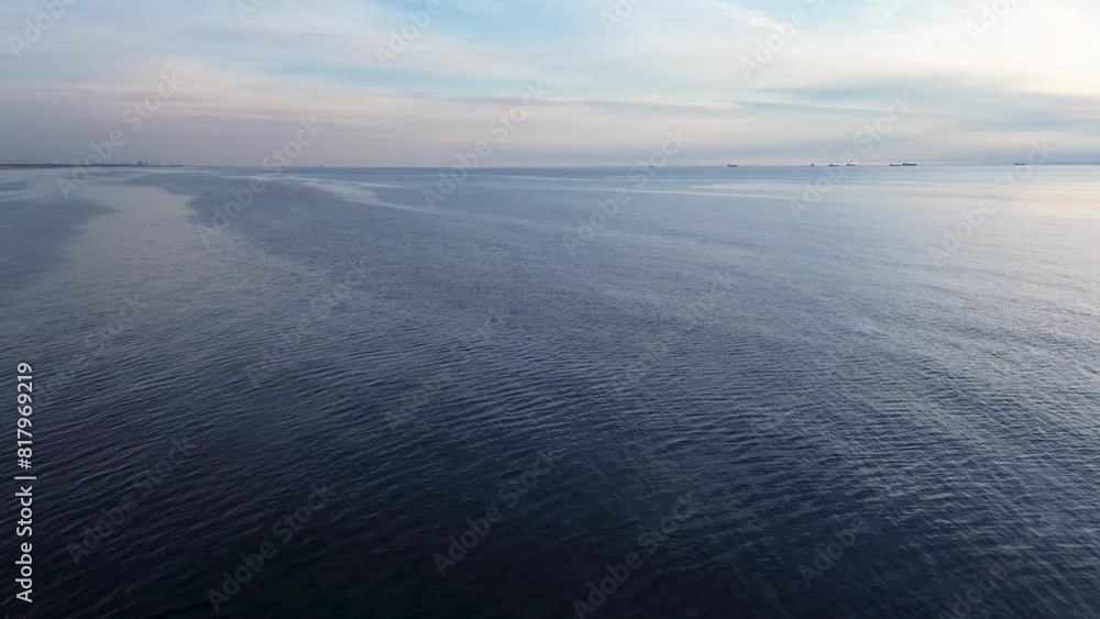Beautiful sunset over the sea, ocean. A lonely athlete, resting, rows on a board. Top view from a quadcopter. Beautiful flight. Ships and windmills on the horizon. Beautiful sunset over the sea, ocean. A lonely athlete, resting, rows on a board. Top view from a quadcopter. Beautiful flight. Ships and windmills on the horizon.