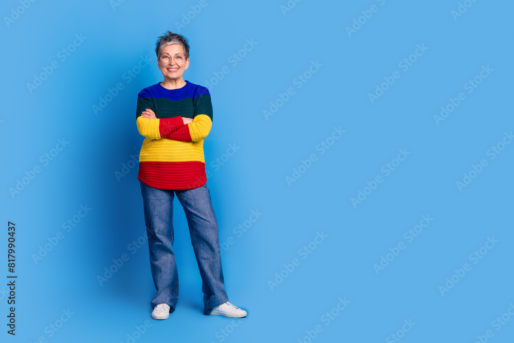 Photo of cheerful glad lovely senior woman wear stylish clothes empty space isolated on blue color background Photo of cheerful glad lovely senior woman wear stylish clothes empty space isolated on blue color background