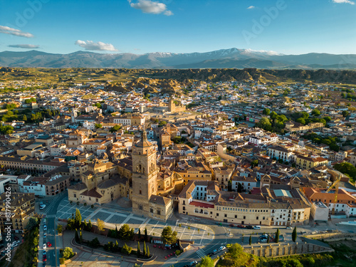Aerial view of city center of Guadix, Spain. Beautiful warm colours at sunset. Cathedral of Guadix in the middle of the city. Travel destination in Granada Province. Sierra Nevada Mountain.